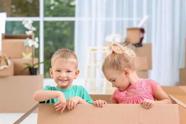 Lindos niños pequeños jugando con la caja móvil en la casa nueva — Foto de Stock