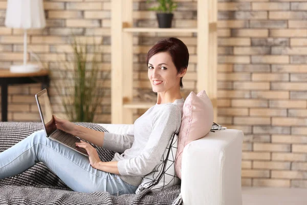 Mulher madura bonita com laptop em casa — Fotografia de Stock