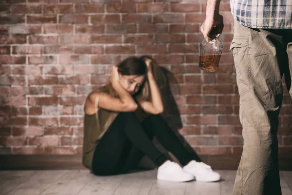 Мужчина с бутылкой алкоголя и молодая женщина — стоковое фото