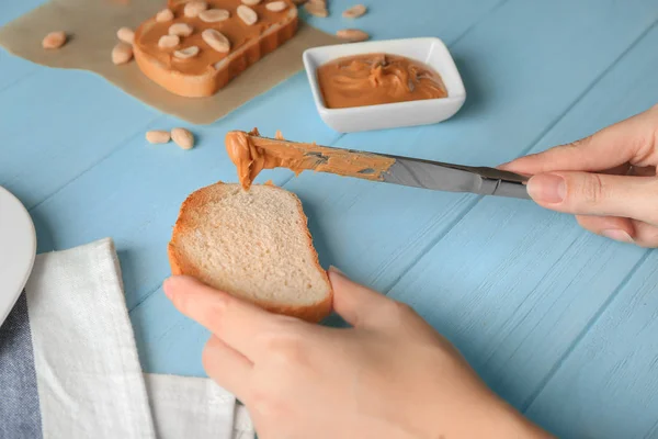 Woman spreading peanut butter — Stock Photo, Image