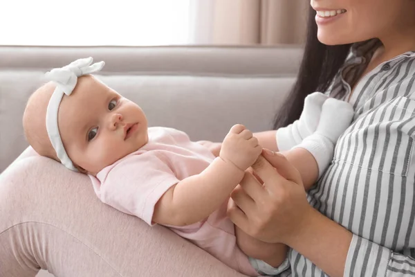 Söt baby håller moderns finger hemma — Stockfoto