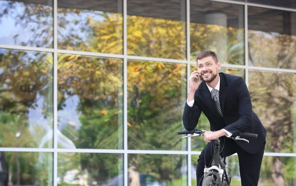 Красивый бизнесмен с велосипедом — стоковое фото