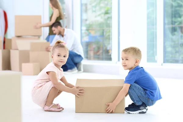 Niños felices con caja móvil en su nueva casa —  Fotos de Stock