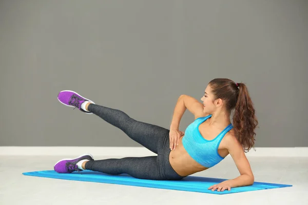 Sportliche junge Frau trainiert im Fitnessstudio — Stockfoto
