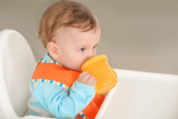 Cute baby drinking water in kitchen — Stock Photo, Image