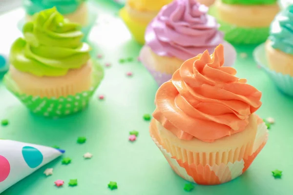 Leckere Cupcakes auf farbigem Hintergrund — Stockfoto