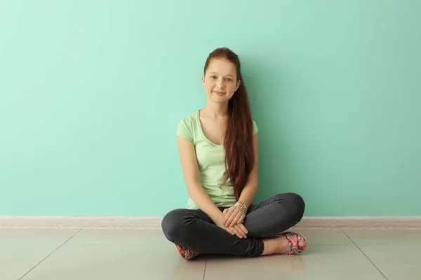 Carino adolescente ragazza seduta sul pavimento in camera vuota — Foto Stock