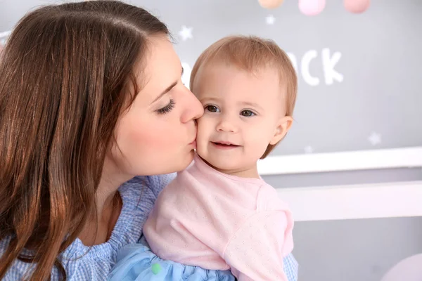 Young mother kissing cute baby at home — Stock Photo, Image