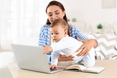 Ev ofisinde çalışırken holding bebek genç anne