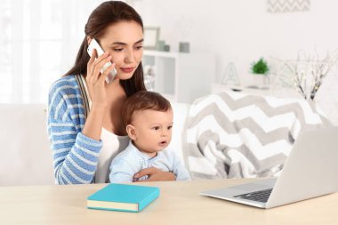 Ev ofisinde çalışırken holding bebek genç anne