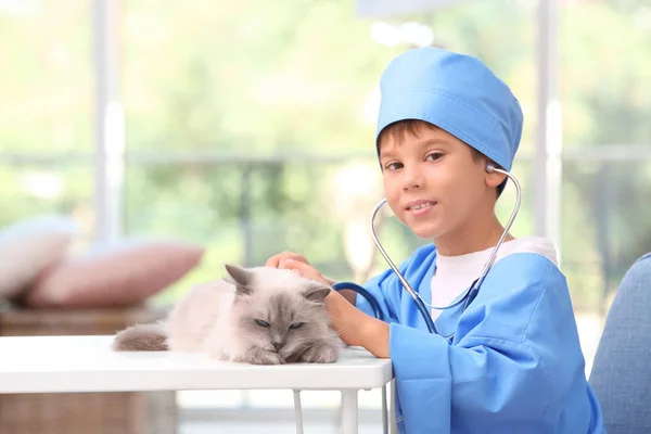 Niño en médico uniforme jugando con gato — Foto de Stock