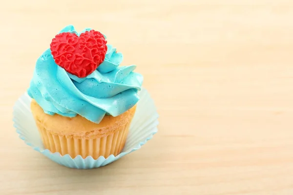 Beautiful cupcake on light wooden background — Stock Photo, Image