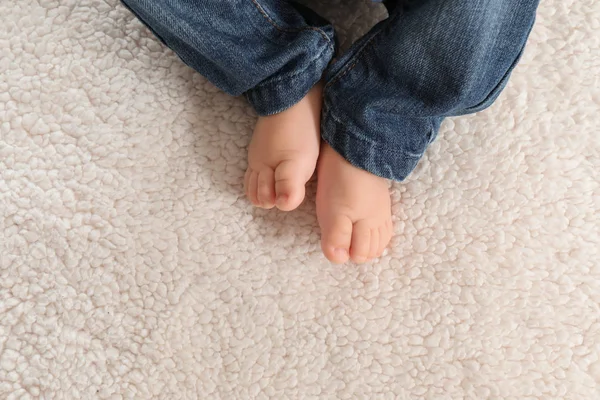Baby feet on light plaid, closeup — Stock Photo, Image