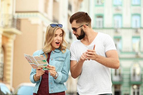 Young tourists with map on the street