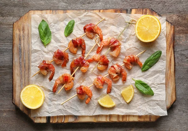 Board with skewered shrimps wrapped in bacon — Stock Photo, Image