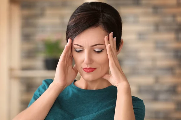 Beautiful mature woman suffering from headache at home — Stock Photo, Image