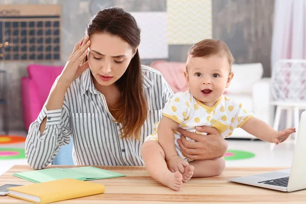 Ev ofisinde çalışırken holding bebek genç anne