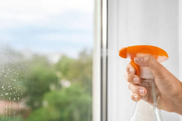 Cleaner washing window with spray — Stock Photo, Image