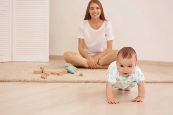 Młoda matka i słodkie dziecko bawiące się na piętrze w domu — Zdjęcie stockowe