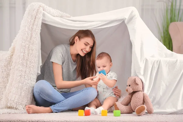 Młoda matka i słodkie dziecko bawiące się w namiocie w domu — Zdjęcie stockowe