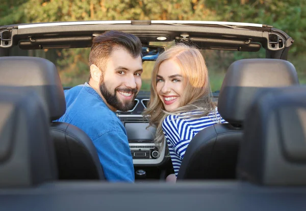 快乐的年轻夫妇坐在车上 — 图库照片