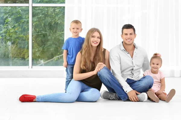 Familia feliz sentada en el suelo en su nueva casa —  Fotos de Stock