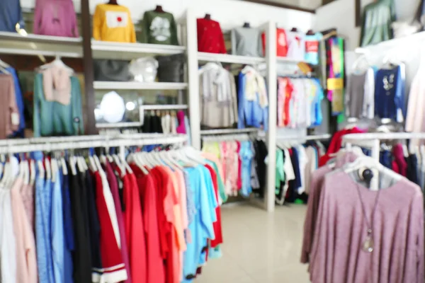 Vista borrosa de las diferentes prendas femeninas en la tienda moderna — Foto de Stock