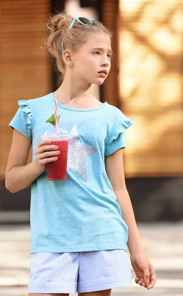 Pequena menina da moda beber smoothie ao ar livre — Fotografia de Stock