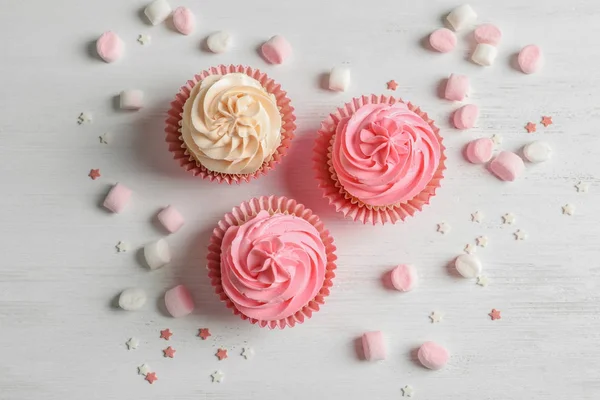 Yummy cupcakes on wooden table — Stock Photo, Image