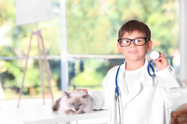 Niño en médico uniforme jugando con gato —  Fotos de Stock
