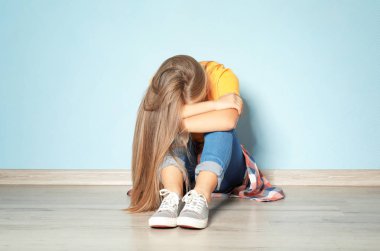 Boş odada katta oturan üzgün genç kız