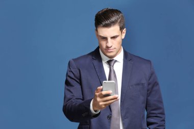 Yakışıklı işadamı cep telefonunuzun renk arka plan