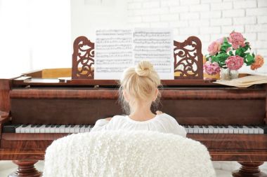 Little girl playing piano indoors clipart