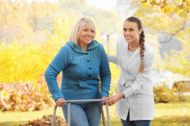 Yürüyen çerçeveli yaşlı kadın. 