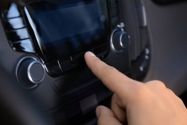 Adam arabanın radyosunu ayarlama