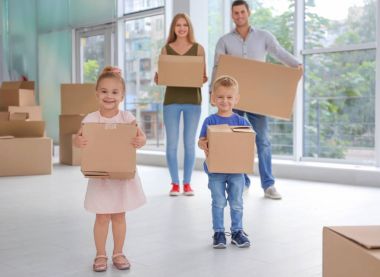 Yeni evlerinde kutuları taşıyan mutlu bir aile.