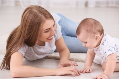 Genç anne ve şirin bebek evde katta oynama