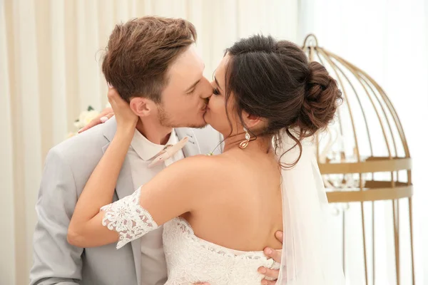 Ευτυχισμένο ζευγάρι όμορφη φιλί την ημέρα του γάμου, σε εσωτερικούς χώρους — Φωτογραφία Αρχείου