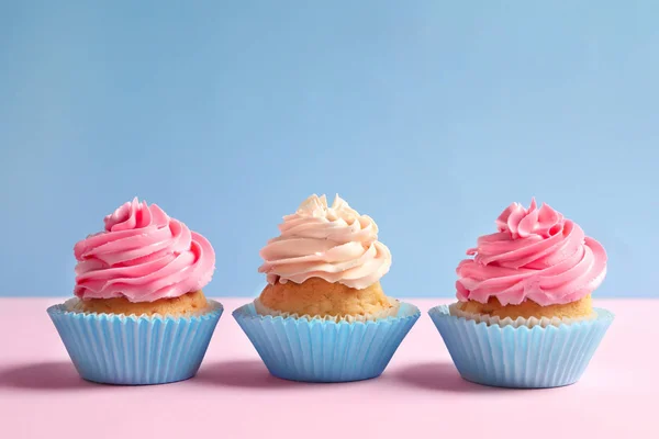 Leckere Cupcakes auf farbigem Hintergrund — Stockfoto