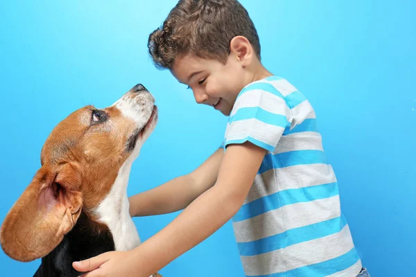 Schattige jongen met hond op kleur achtergrond — Stockfoto