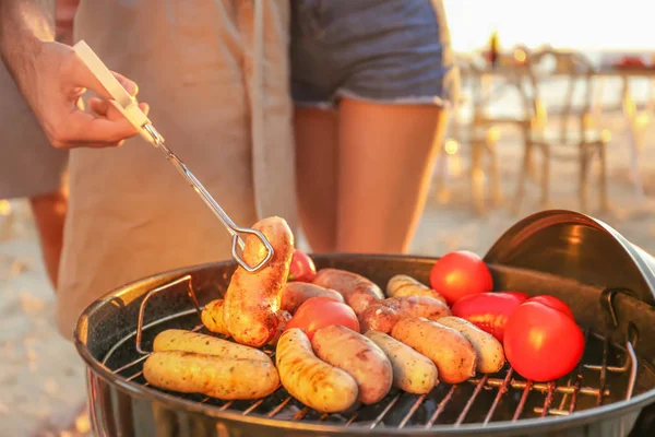 Hombre cocinando salchichas y verduras en la parrilla barbacoa —  Fotos de Stock