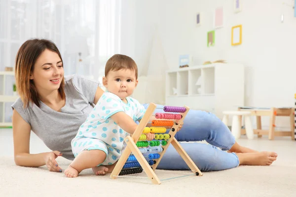 Mor med baby boy spelar hemma — Stockfoto