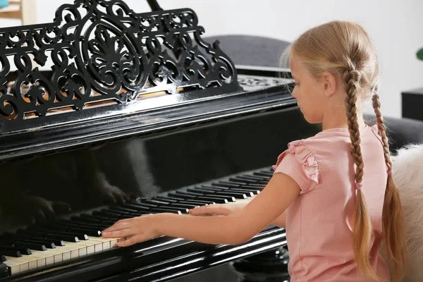 Девочка играет на пианино в помещении — стоковое фото