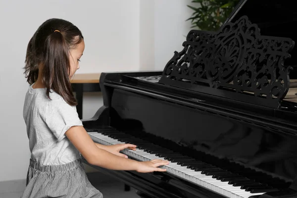 Liten flicka spela piano inomhus — Stockfoto