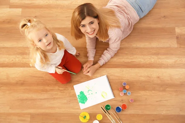 Mère avec fille mignonne peinture tableau sur feuille de papier, à l'intérieur — Photo