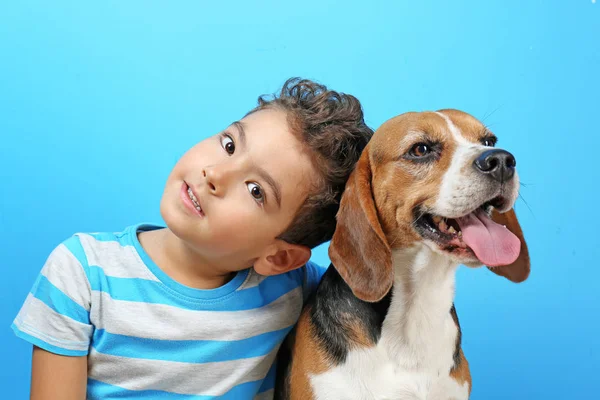 Милий хлопчик з собакою на кольоровому фоні — стокове фото