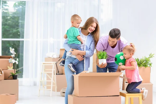 Família feliz desempacotando caixas móveis em sua nova casa — Fotografia de Stock
