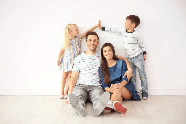 Familjen nära väggen i sitt nya hem — Stockfoto