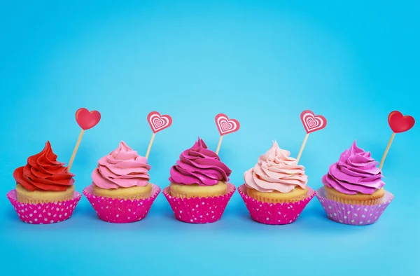 Leckere Cupcakes auf farbigem Hintergrund — Stockfoto