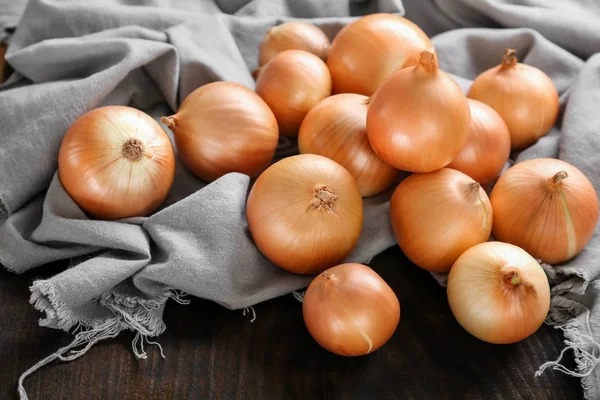 Frische rohe gelbe Zwiebel auf Stoff — Stockfoto